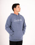 Southerly Script Hoody in Flint Blue, three-quarter studio view with kangaroo pocket