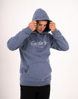 Southerly Script Hoody in Flint Blue, studio view with hood up